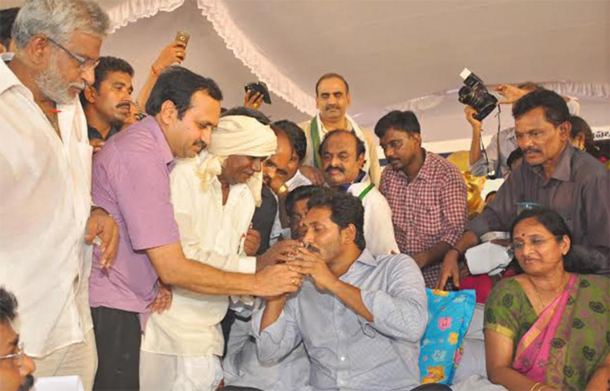 A farmer giving lemon juice to YSR Congress president Y S Jaganmohan Reddy to mark the end of his Samara Deeksha in Mangalagiri in Guntur district on Thursday
